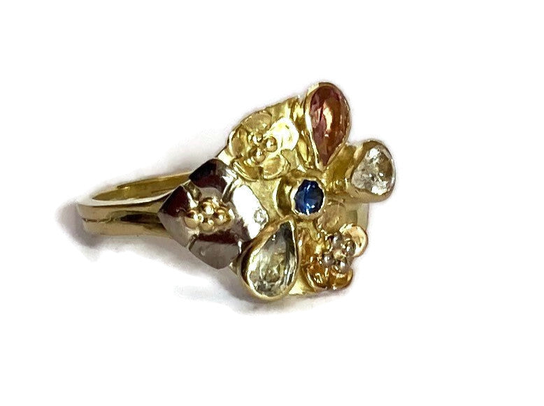 side view of floral sapphire cocktail ring, on white background