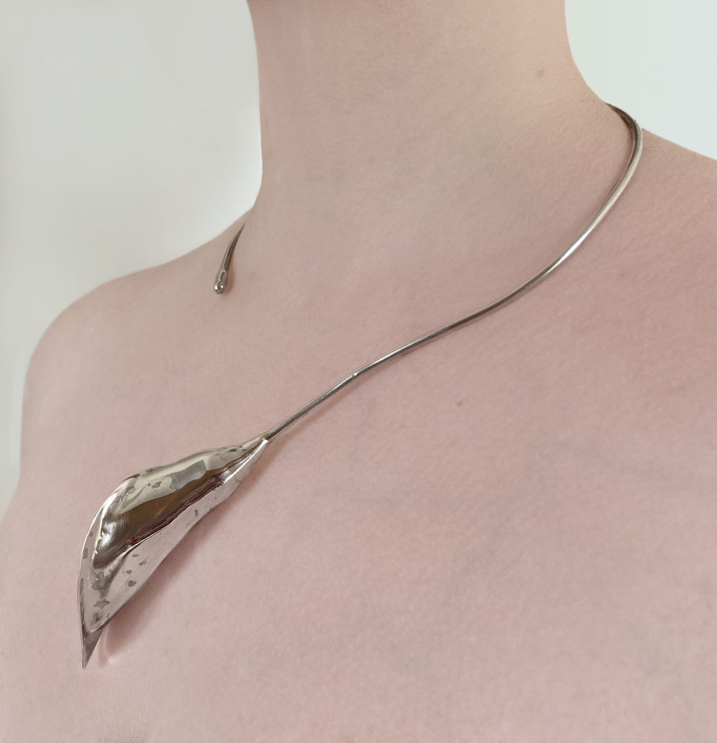 elegant hand forged cala lily torque in sterling silver shown on neck