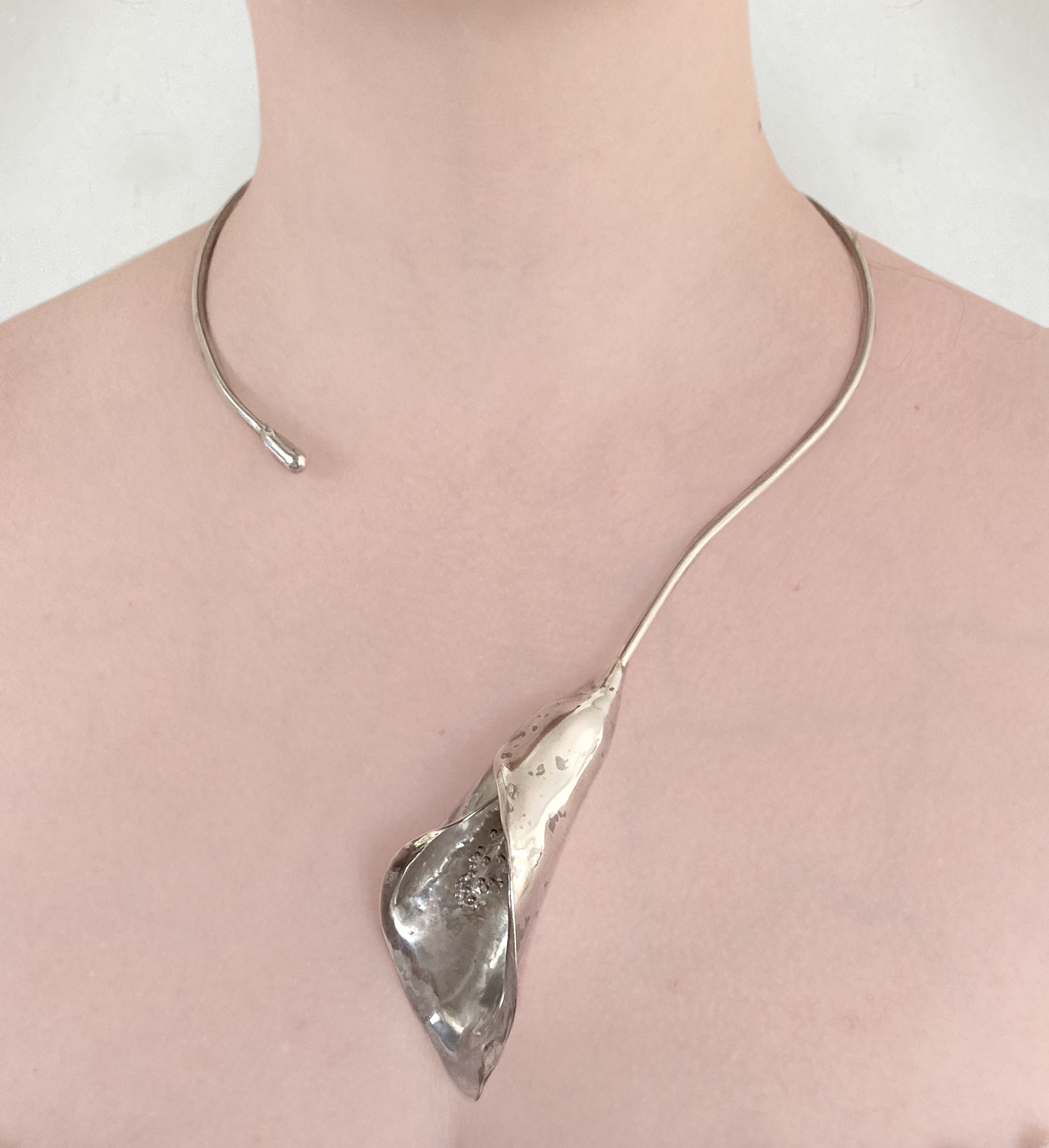 hand forged sterling silver cala lily statement torque necklace on neck