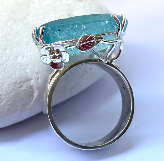 rambling rose silver and aquamarine cocktail ring, resting on white pebble