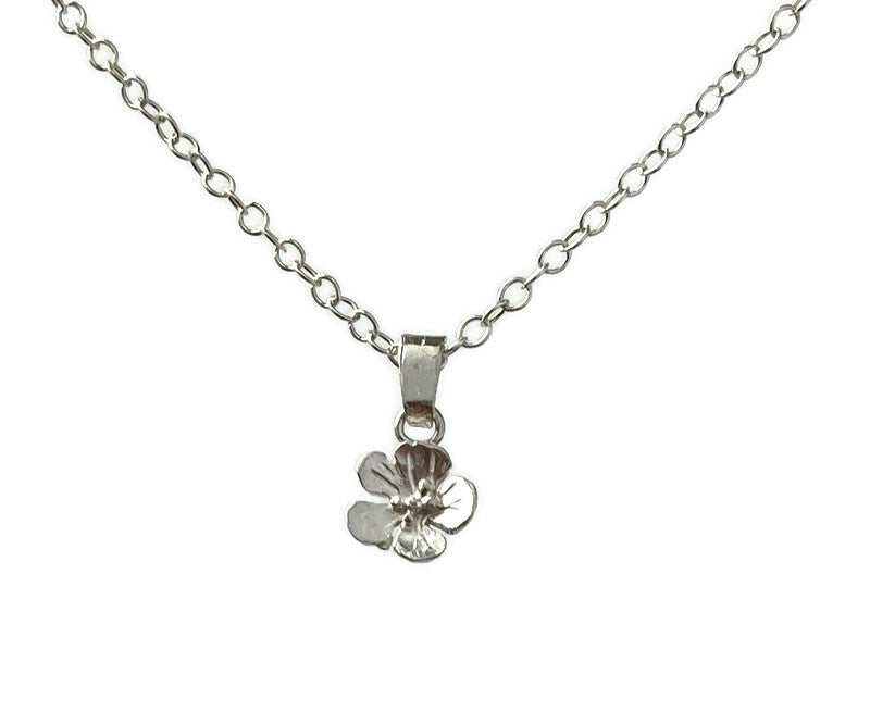 dainty detailed flower pendant and chain on white background