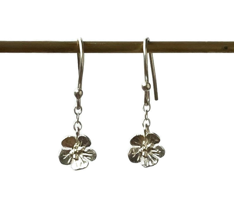 two hook flower earrings hanging on thin rod , on white background