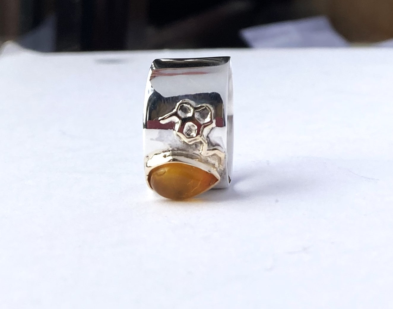 gold and silver wide ring with honeycomb detail and amber stone, on white background