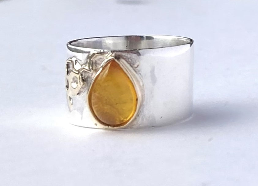 amber pear shape stone on wide silver ring, on white background