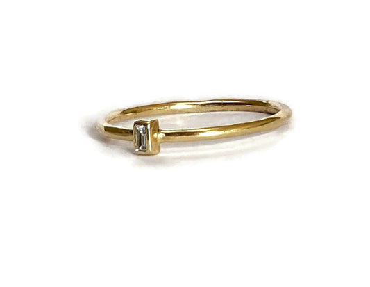 diamond baguette gold solitaire ring on white background