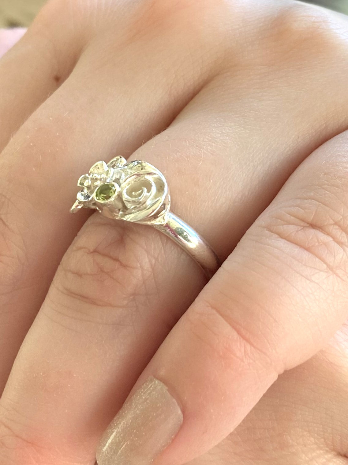 floral cluster ring with roses and green peridot, on ladies hand