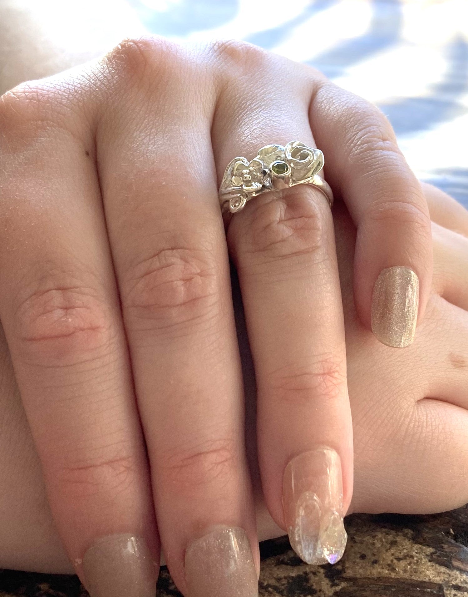 pretty floral ring set with green periot, on ladies hands