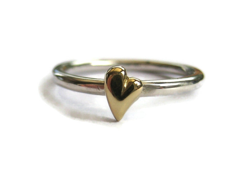 silver and gold heart ring on white background