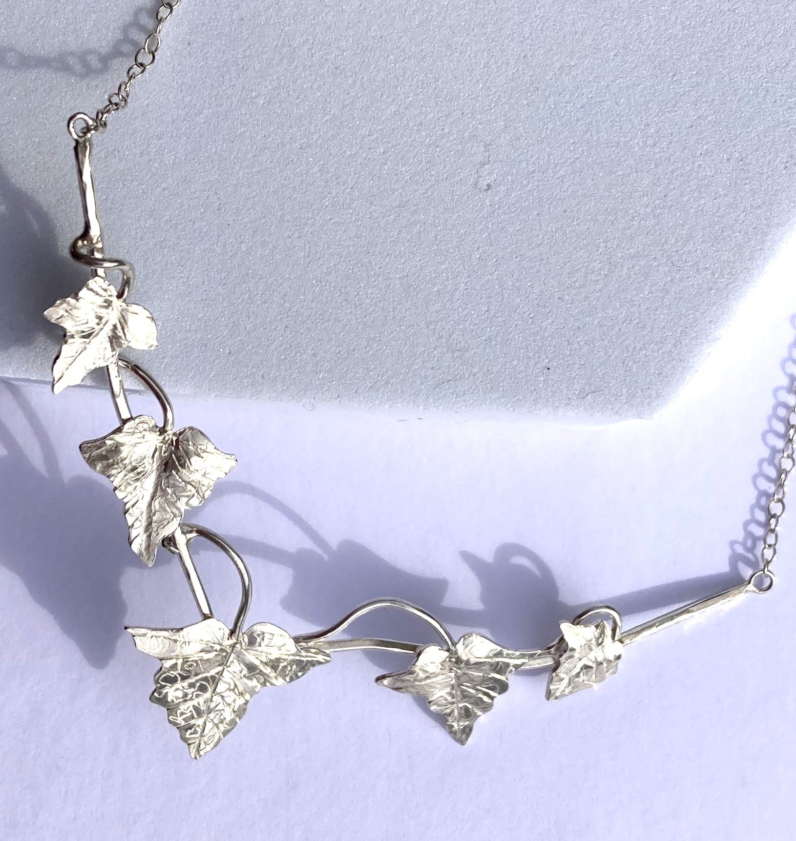 hand made detailed ivy leaves necklace on grey background