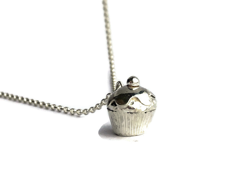 tiny hand forged silver cupcake pendant on white background