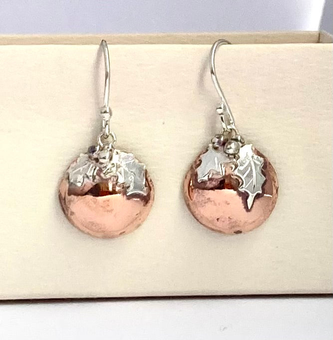 fun handmade Christmas pudding dome earrings with silver holly leaves , on beige background 