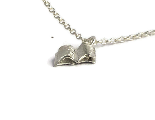 Sweet miniature open book pendant handmade in sterling silver, on white background