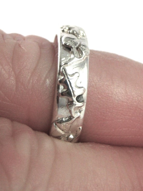 oak and acorn pattern wedding ring on finger