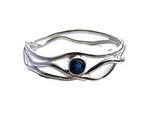 silver wire ring set with small round sapphire, white background